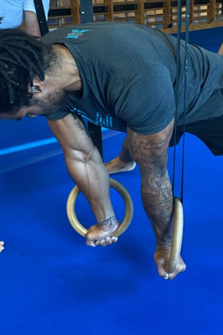 Photo of adults doing gymnastics strength training classes focused on strength training, mobility training, and skill training on gymnastics rings
